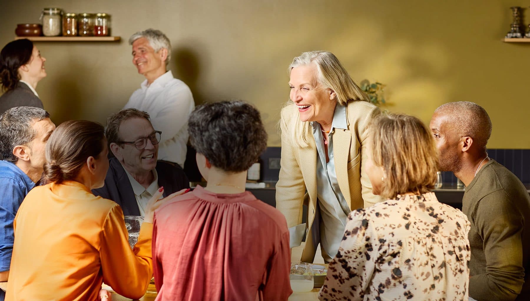 A woman laughing with friends in a bright room
